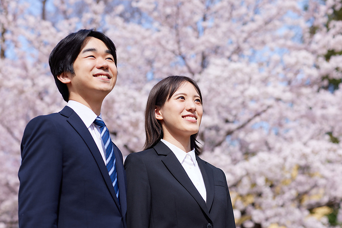 Japanese business men and women with cherry blossoms and smiles