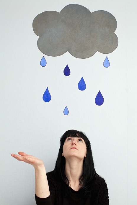 Woman standing under painted rain cloud