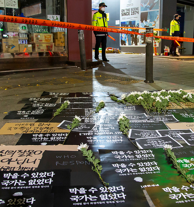 Itaewon s Halloween crowd crush in Seoul Halloween tragedy in Seoul s Itaewon district, November 2, 2022 : Policemen stand guard at an alley in Itaewon district in Seoul, South Korea, where the Halloween crowd crush killed at least 156 people. Signs which protesters put to mourn for the victims and to blame the government and President Yoon Suk Yeol, read,  The disaster could be prevented. There was no government .  Photo by Lee Jae Won AFLO   SOUTH KOREA 