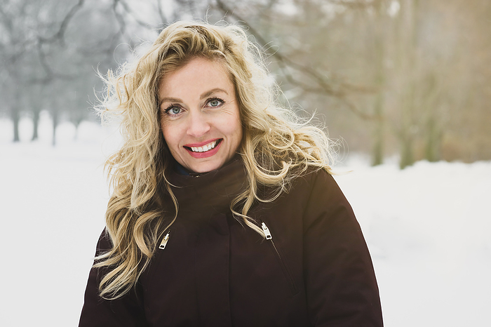 woman enjoying a winter walk through snow covered park
