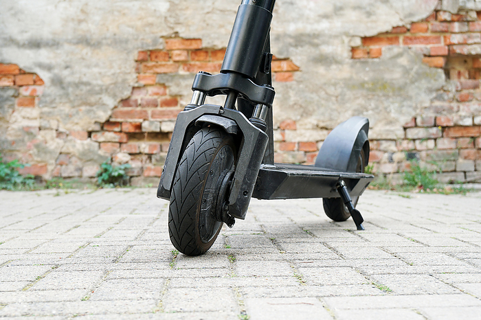 Electric kick scooter or e-scooter parked on pavement