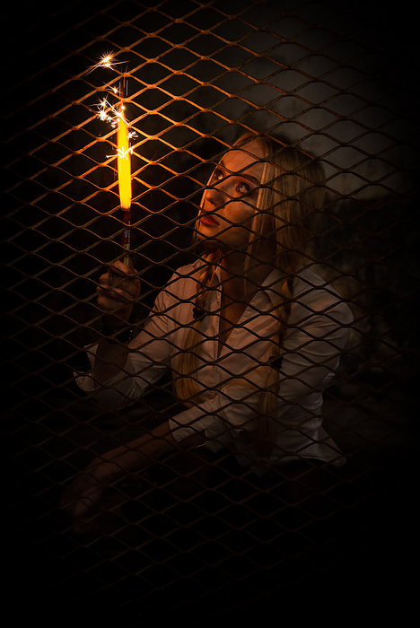 Portrait of caucasian woman behind metal frame holding a fire stick. Home isolation Portrait of caucasian woman behind metal frame holding a fire stick. Home isolation
