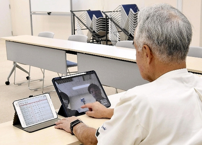 Telemedicine 1 General Director Mochizuki examines a patient via video call using a tablet terminal. The terminal on the left displays the patient s heart rate and other data  10:54 a.m., August 8, 2012, at Ohara, Hachimantai City  Saito Arata Photo