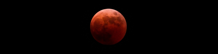 Red moon completely in the shadow of the earth during a total lunar eclipse.