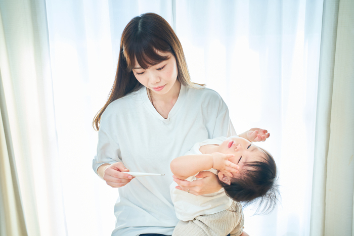 Japanese boy having his temperature measured by his mother (People)