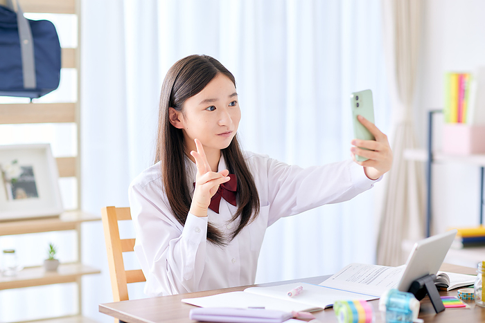 Japanese junior high school girls taking selfies while studying