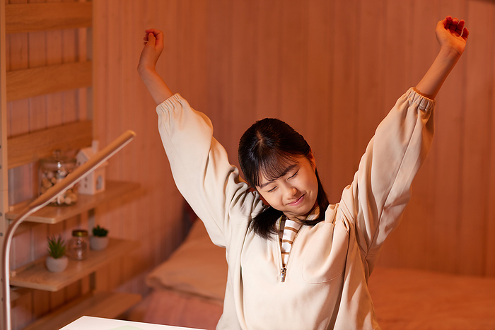 Japanese girl stretching while studying