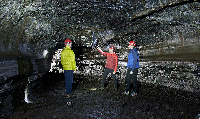 Inside Hlidarrendi cave group of scientists exploring the Leidarendi lava cave in Iceland