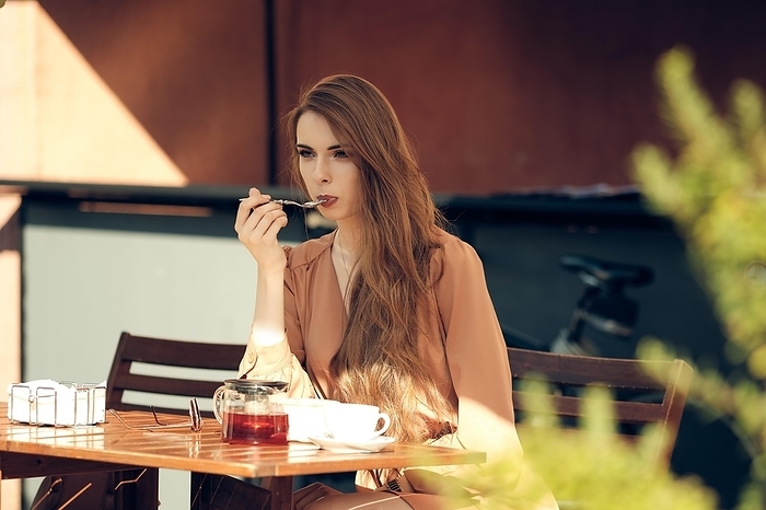 Beautiful young woman has coffee break in the middle of sunny day, Photo by Aleksei Isachenko
