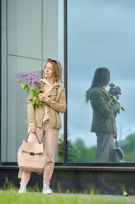 Sporty active senior woman with branch of lilac in her hands, Photo by Aleksei Isachenko