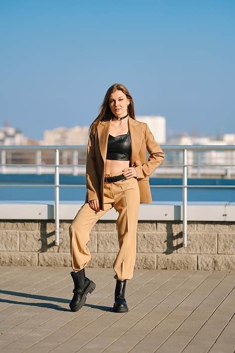Street fashion, women casual and trendy outfit. Woman in pantsuit, leather tank-top and rough boots outdoor, Photo by Aleksei Isachenko