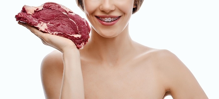 Unrecognizable happy woman holds fresh beef steak in hand isolated on white background, Photo by Aleksei Isachenko