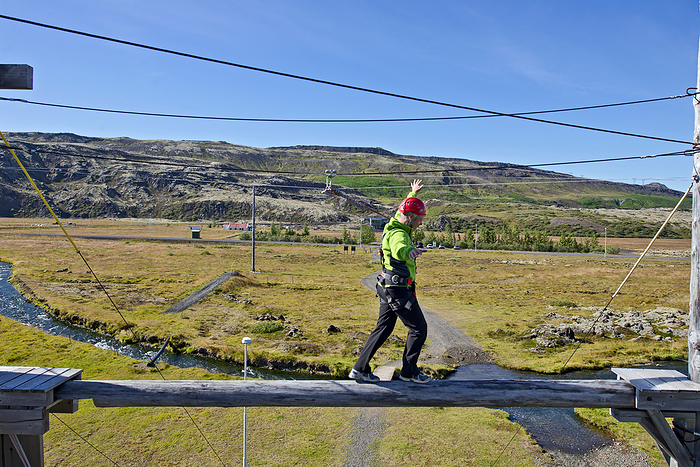 high rope course man balancing on plank at high rope access course in Iceland