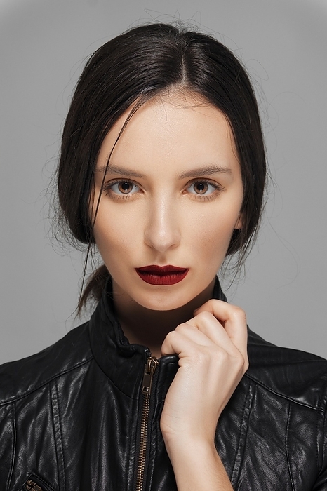 Charming girl in leather jacket touching collar. Red mat lips, Photo by Aleksei Isachenko