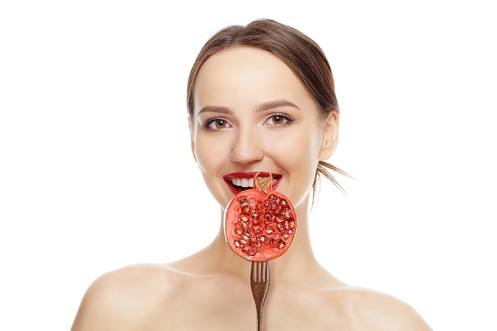 Beautiful fashion model with perfect skin, natural makeup and red lips with pomegranate isolated on white background, Photo by Aleksei Isachenko