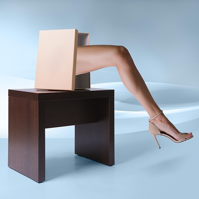Beautiful female leg in high heel shoe sticking out of the shoe box, Photo by Aleksei Isachenko