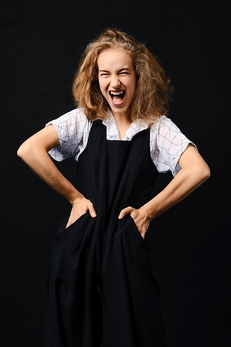 Low key portrait of screaming girl with hands on her waist, Photo by Aleksei Isachenko