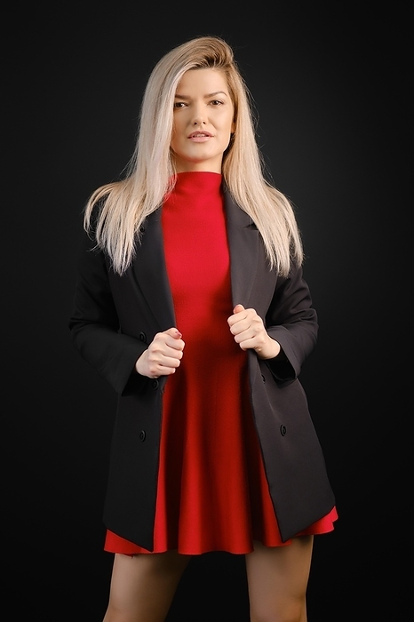 Pretty woman in red dress and black jacket posing in dark studio, Photo by Aleksei Isachenko