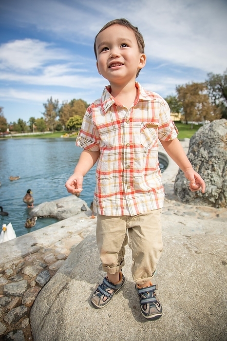 Young chinese and caucasian boy having fun at the park and duck pond, Photo by Andy Dean