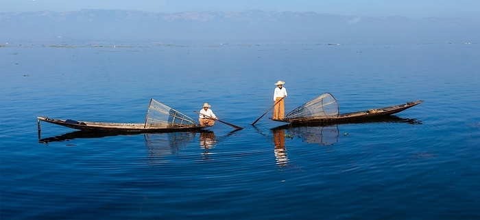 Panorama of traditional Burmese fishermen with fishing net at Inle lake in Myanmar famous for their distinctive one legged rowing style, Photo by Dmitry Rukhlenko