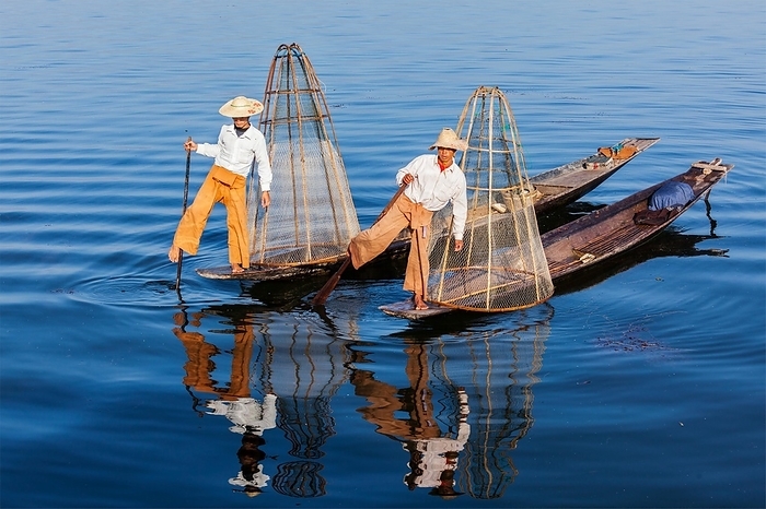 Myanmar travel attraction landmark, Traditional Burmese fishermen with fishing net at Inle lake in Myanmar famous for their distinctive one legged rowing style, Photo by Dmitry Rukhlenko