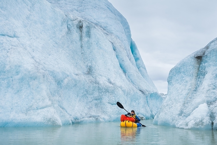 Woman with packraft at sea, iceberg behind, Greenland, North America, Photo by Gabriel Gersch
