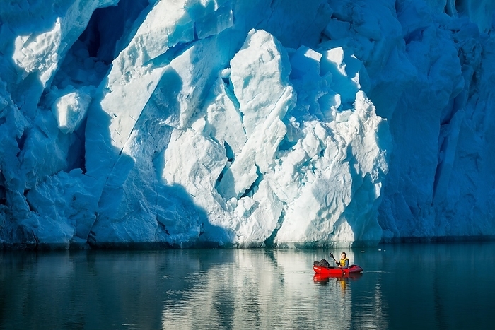 Man with packraft on fjord, glacier behind, Greenland, North America, Photo by Gabriel Gersch
