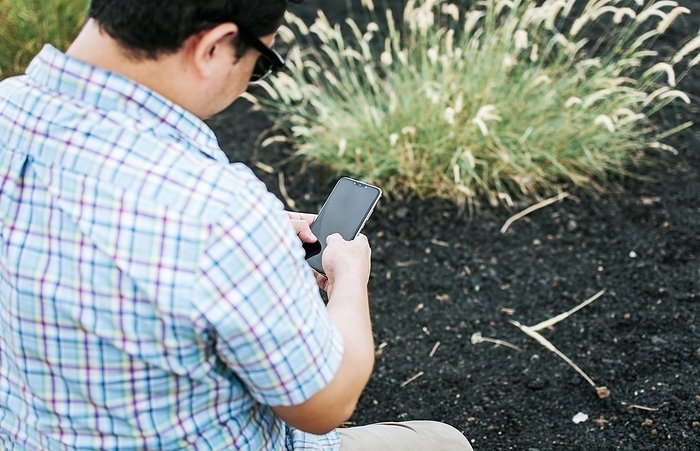 View of a man with cell phone in hand, closeup of man using cell phone and showing screen, young man sitting with cell phone showing blank screen, Photo by Isai Hernandez