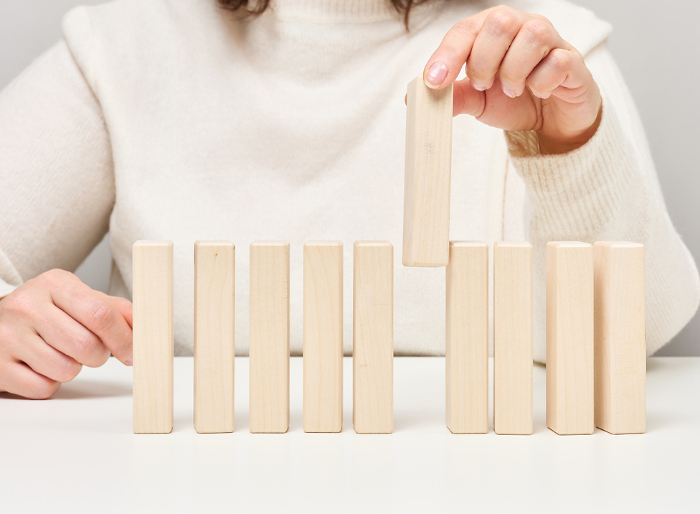 Wooden blocks on the table, a woman s hand holds one. The concept of finding unique, talented employees Wooden blocks on the table, a woman s hand holds one. The concept of finding unique, talented employees