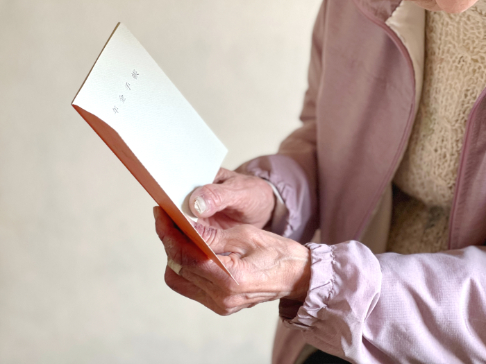 Elderly woman's hand holding pension book