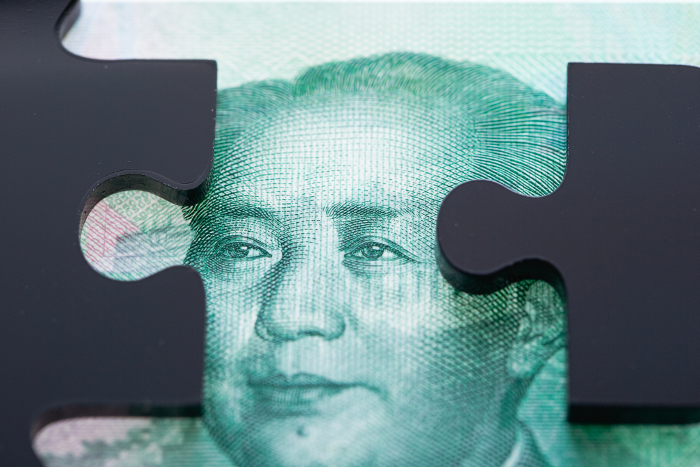 Chinese renminbi banknotes and black jigsaw puzzle