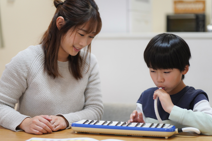 Parents and children practicing keyboard harmonica
