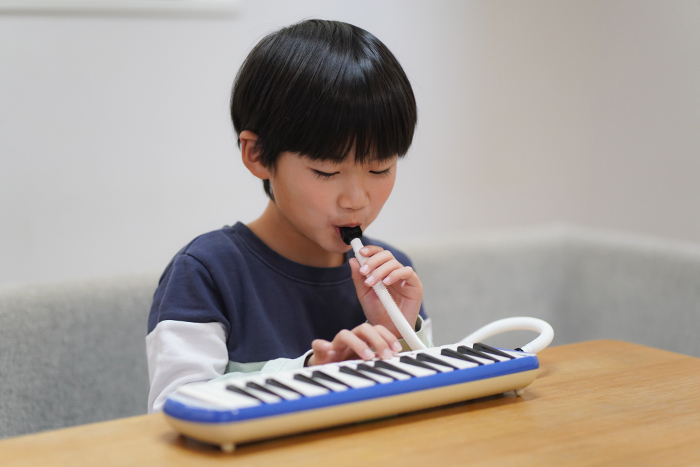 A boy practicing the keyboard harmonica