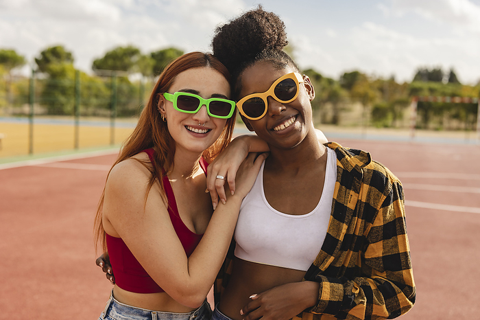 Young women wearing sunglasses standing in sports court