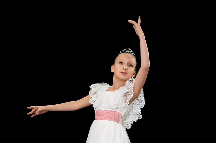 Charming girl ballerina in white dress dancing on black background in studio., Photo by Zoonar/Alexander A.
