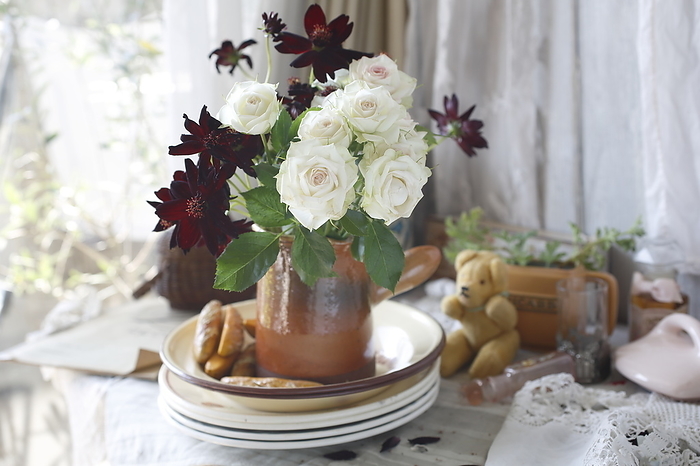 Table flower arrangement of cream roses and chocolate cosmos The rose s name is Elegant Waltz Chocolate Cosmos Vintage Bears