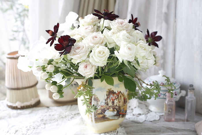 Cream roses and chocolate cosmos flower arrangement in a ceramic bowl Cream roses are an elegant waltz Chocolate cosmos White berries are hypericum Green leaves are rose geraniums
