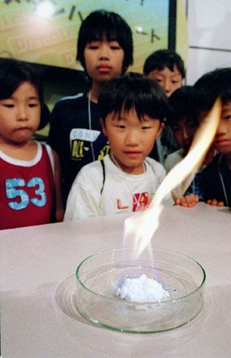 Visitors see burning ice  methane hydrate  at the Mirai Expo   Kobe, Japan From Mirai Experience Expo   Burning Ice  Methane Hydrate  at Kobe International Exhibition Hall, Kobe, Japan, August 3, 2001.