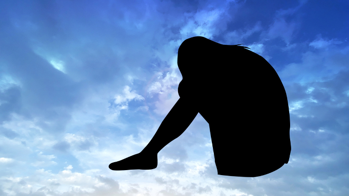 Silhouette of Woman Nodding Her Knees _Suspicious Blue Sky Background_Wide