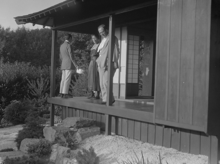 Three people standing on the porch of a Japanese style building in a garden... A.W. Bahr, c1917 1934 Creator: Arnold Genthe. Three people standing on the porch of a Japanese style building in a garden, possibly belonging to A.W. Bahr, between 1917 and 1934.