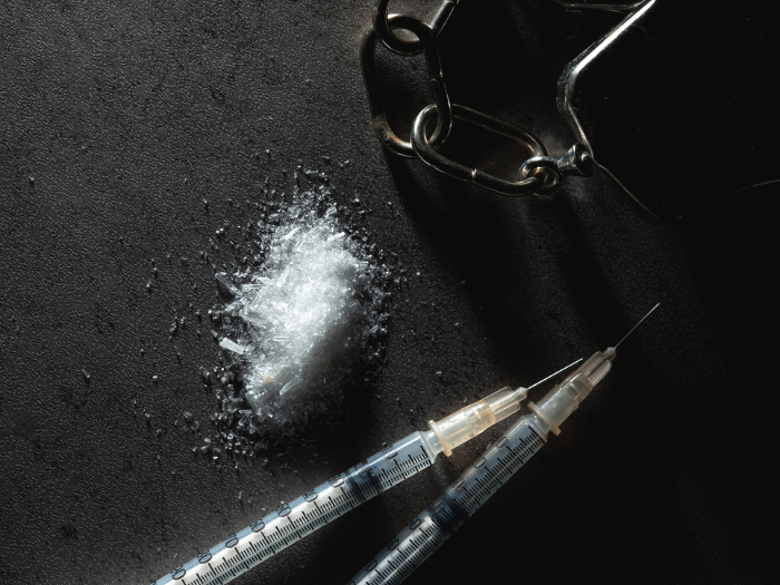 White powder, syringe and handcuffs Drug abuse and arrest image