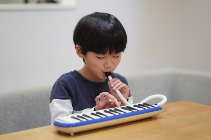 A boy practicing the keyboard harmonica