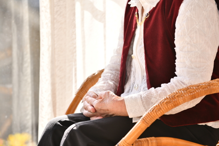 Senior woman looking out from a wicker chair