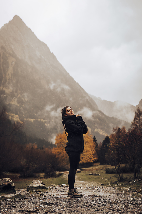 Girl in a path on a mountain route during a cloudy autumn day