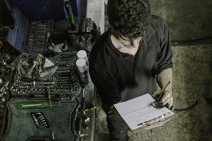 Technician checking paperwork in car service station