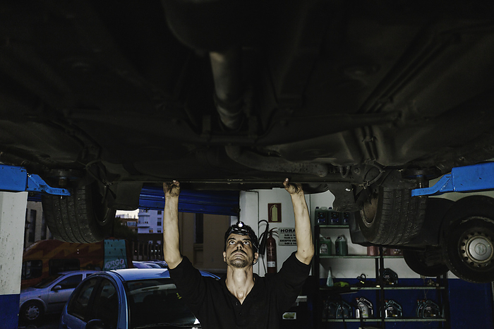 Mechanic examining car in workshop