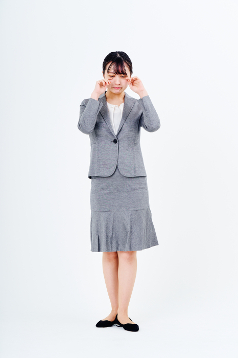 A Japanese woman in a suit is grieving.