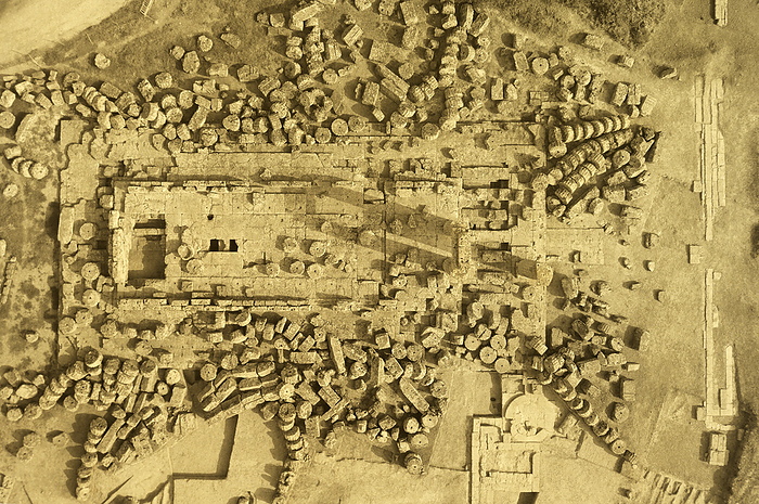 Aerial photo of Temple of Zeus, Nemea. Vintage aerial photograph of the toppled column drums of the Temple of Zeus, Nemea, Greece. Taken in the 1920 s showing only 2 columns and a connecting epistyle, or architrave. Nemea was a religious sanctuary in the northern Peloponnese of Greece where pan Hellenic athletic games were held every two years from 573 BCE until 271 BCE. Architectural remains at the site are dominated by the impressive Temple of Zeus constructed c. 330 BCE. This was built on the site of an earlier temple from the 6th century BC which was destroyed by fire. The wooden and terracotta tiled roof of the temple collapsed in the 2nd century CE and in the 5th century CE the majority of the columns collapsed, not by earthquake but by the removal of blocks from the stylobate. Several columns have been re erected in modern times using largely the original drums which still lie scattered around the site., by DAVID PARKER SCIENCE PHOTO LIBRARY