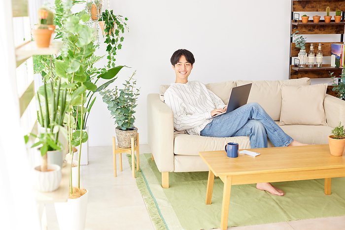 Young Japanese man relaxing on sofa