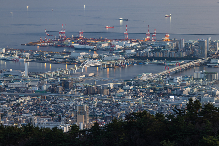 Rokko Island and the city and port of Kobe at dusk viewed from Mt. Rokko Tenran-dai in Kobe, Hyogo, Japan